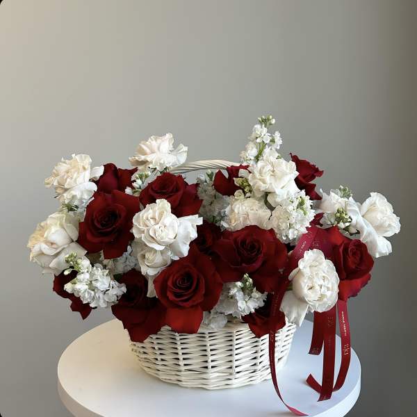 Basket of red and white roses with small white flowers
