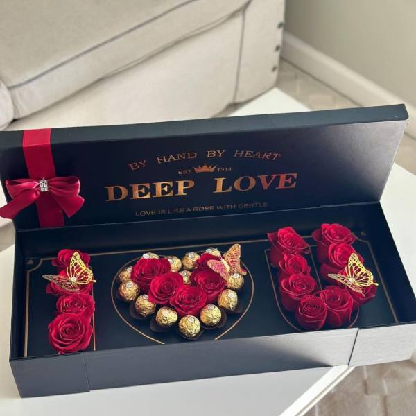 Red roses and chocolates arranged in a black gift box