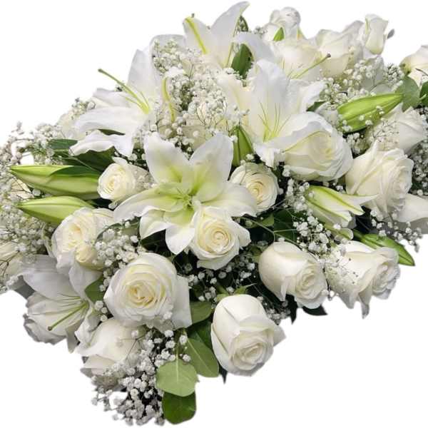 White lilies and roses arranged in a bouquet with baby's breath