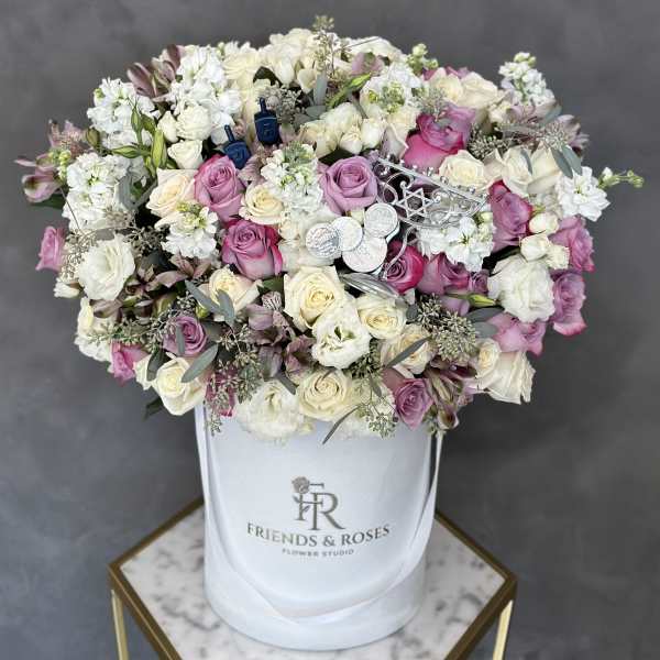 Pink and white roses arranged in a white hat box