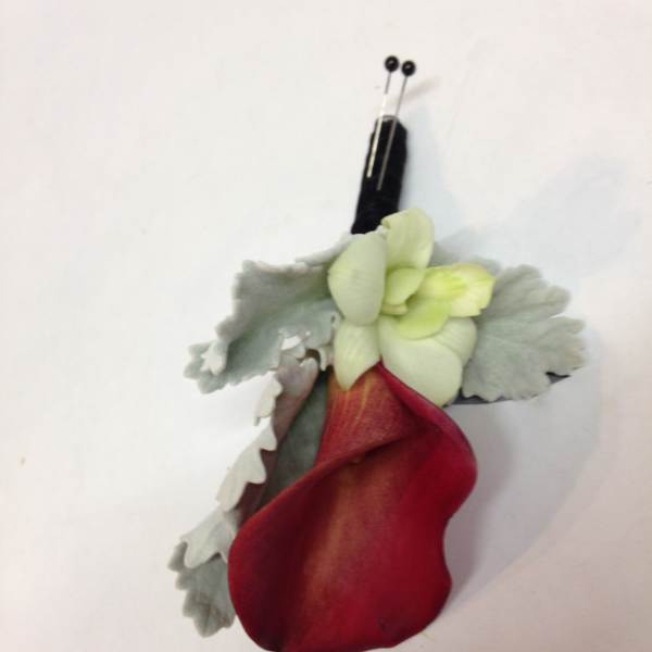 Red and pale green boutonniere with a black pin