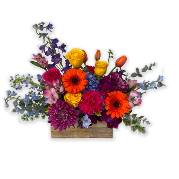 Bright mixed bouquet in a wooden box with orange, yellow, purple, and pink flowers
