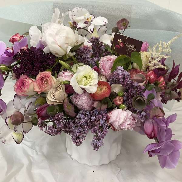 Mixed bouquet in a white vase with purple, pink, and white flowers