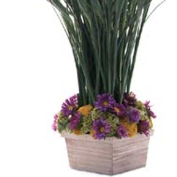 Purple flowers in a square woven basket with tall grass-like stems