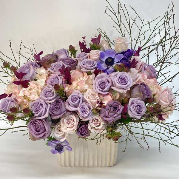 Lavender and blush rose arrangement in a cream vase