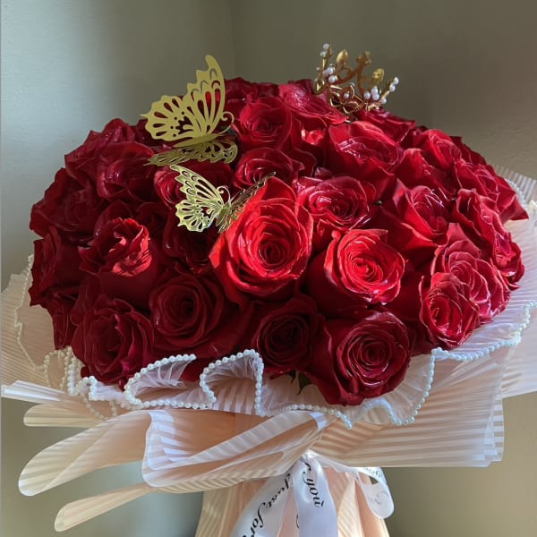 Bouquet of red roses with butterfly picks and a decorative ribbon wrap