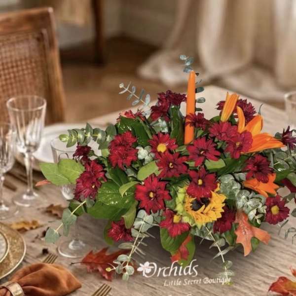Low centerpiece with red and orange flowers in a rectangular container