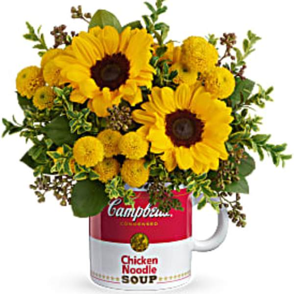 Yellow sunflowers and button mums arranged in a red and white Campbell's soup mug