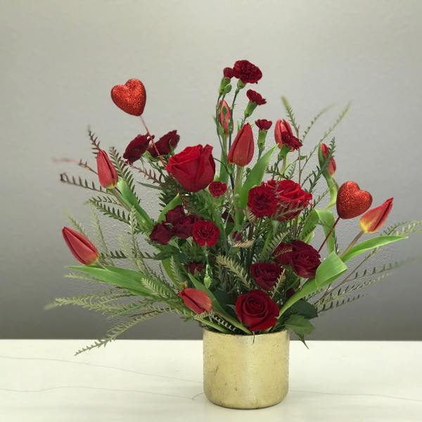 Red roses and tulips in a gold vase with glitter heart picks
