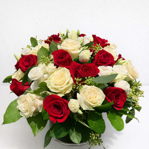 Red and white rose bouquet in a low round container