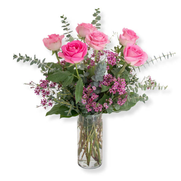 Pink roses and small purple flowers in a clear glass vase