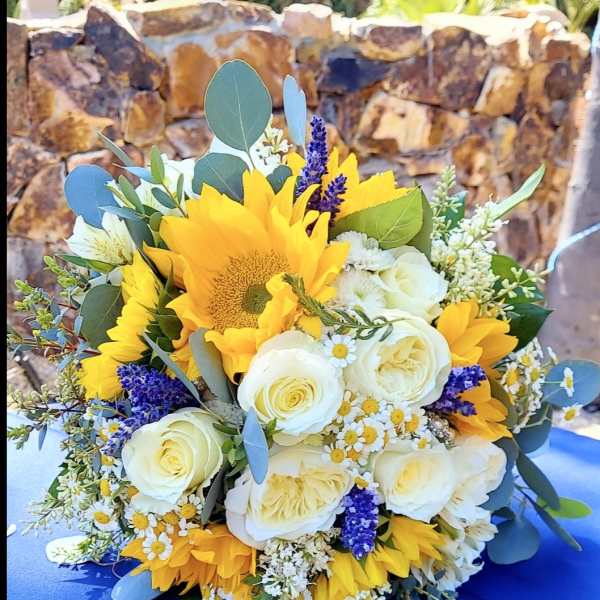 Bouquet of yellow sunflowers and white roses with purple accents