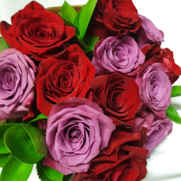 Bouquet of red and lavender roses with green leaves