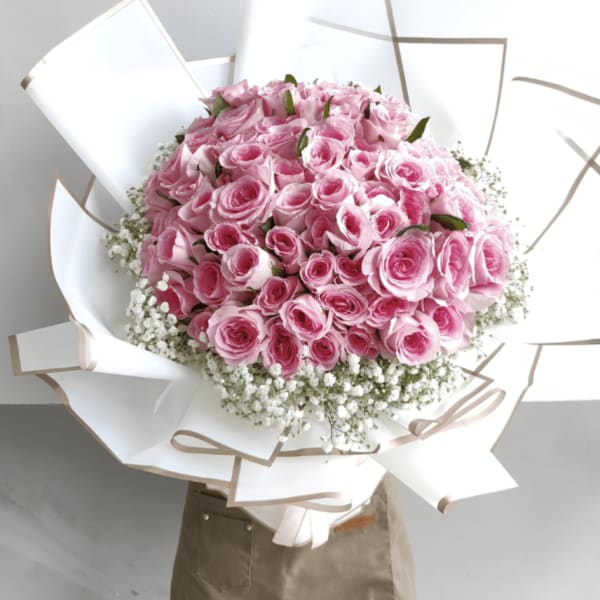 Large bouquet of pink roses wrapped in white paper