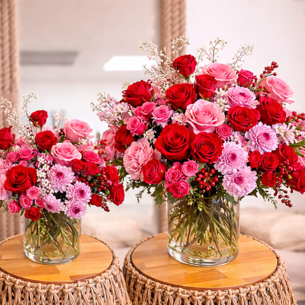 Three red and pink rose bouquets in clear glass vases
