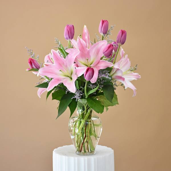 Pink lilies and tulips in a clear glass vase