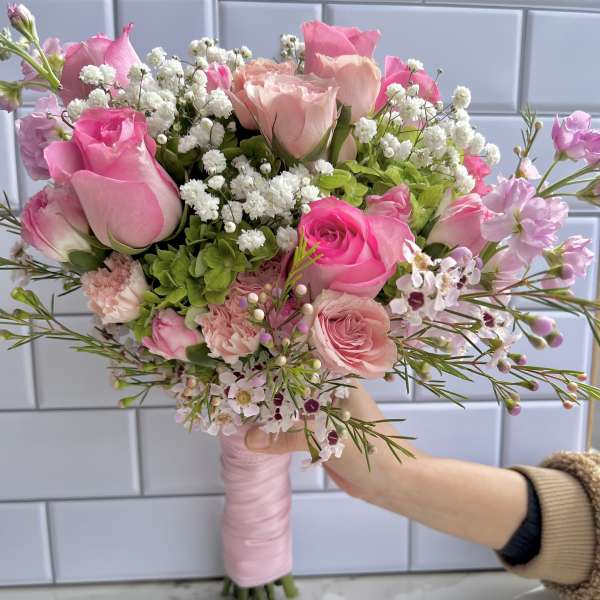 Hand-tied bouquet of pink roses and white baby's breath