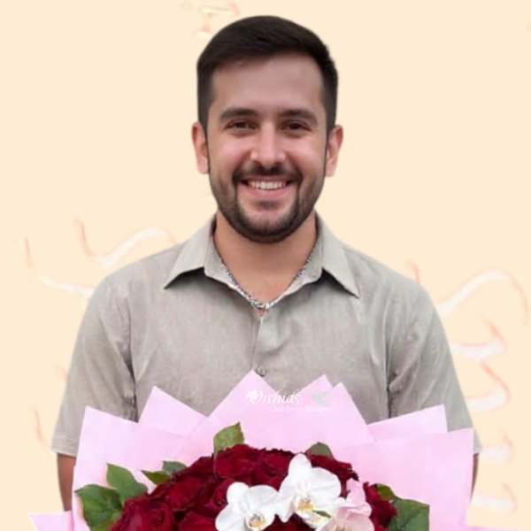 Man holding a bouquet of red roses with white orchids