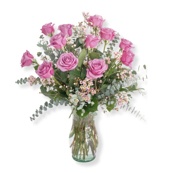 Pink roses arranged in a clear glass vase with airy filler flowers