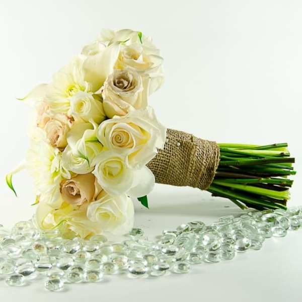 Bouquet of cream and white roses wrapped in burlap