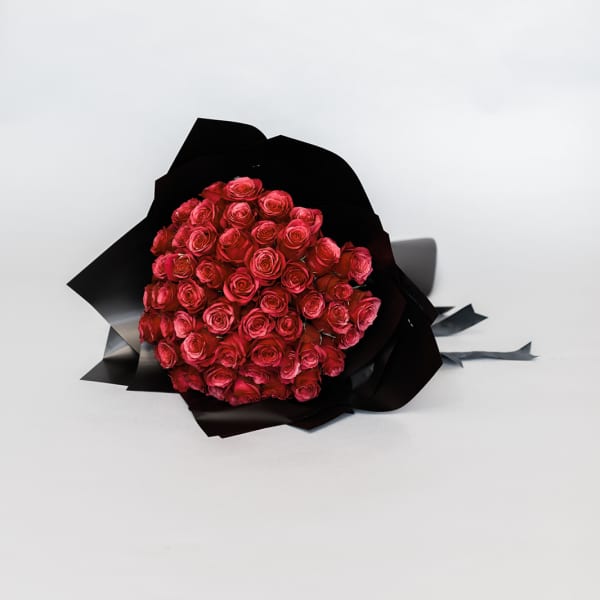 Bouquet of red roses wrapped in black paper