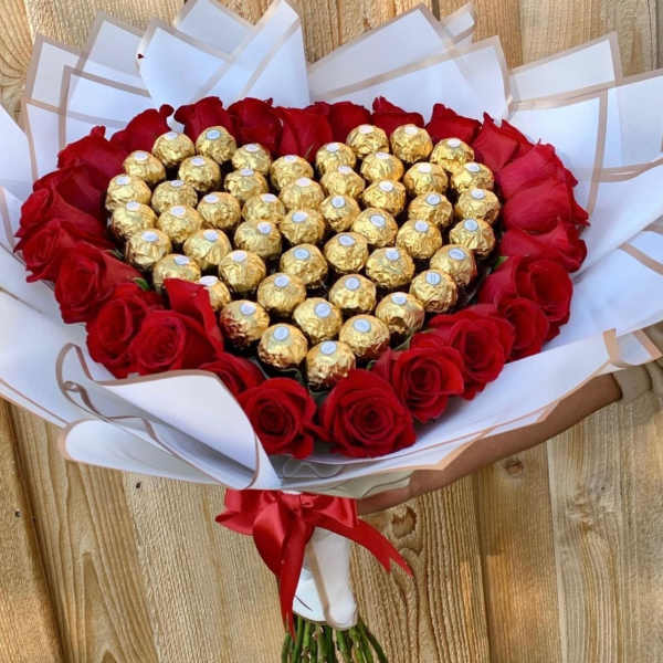 Heart-shaped bouquet of red roses with gold-wrapped chocolates