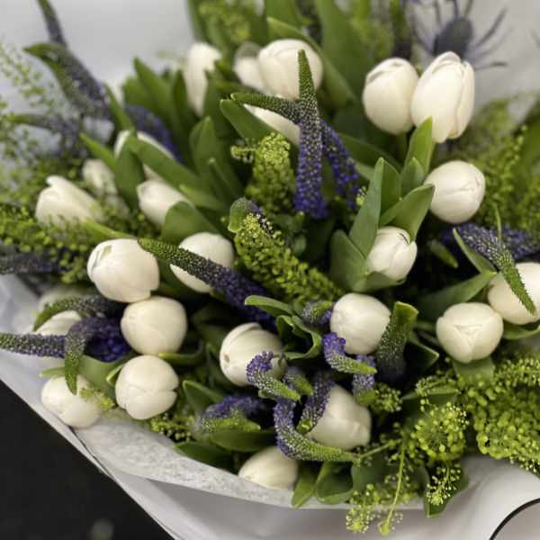 Bouquet of white tulips with purple spikes and green filler
