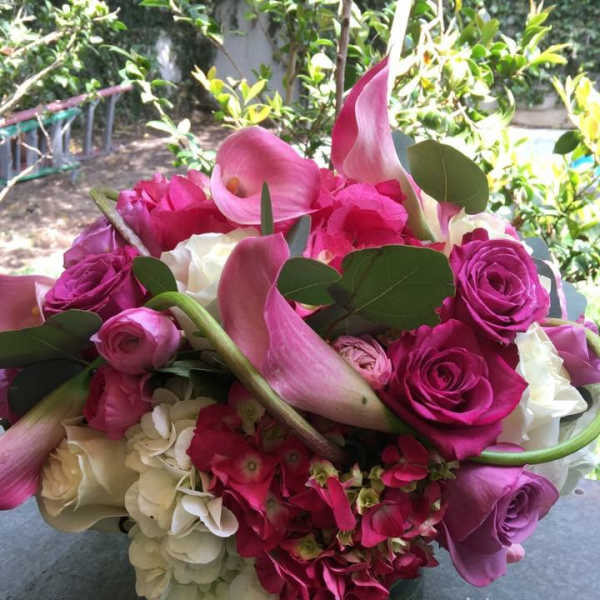Pink and white bouquet with calla lilies, roses, and hydrangeas in a glass vase