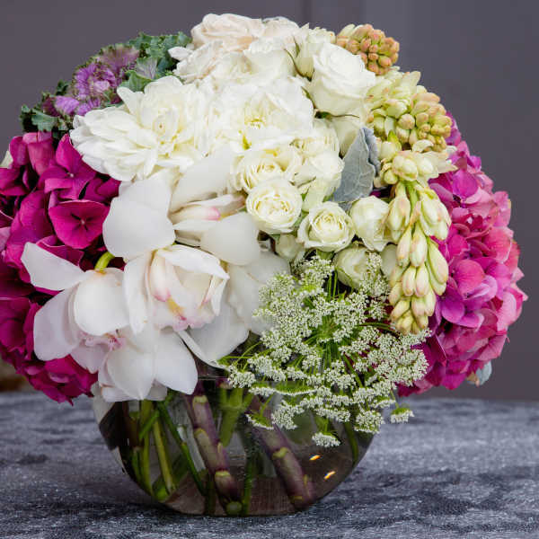 Bouquet of white and magenta flowers in a clear glass vase