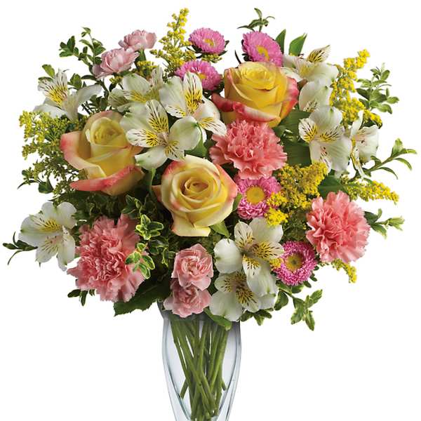 Mixed bouquet of roses, carnations, and white alstroemeria in a glass vase