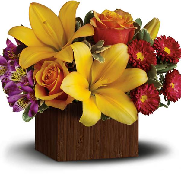 Bouquet of yellow lilies, orange roses, and purple flowers in a wooden box