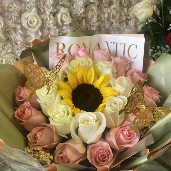 Bouquet of pink and white roses with a sunflower center