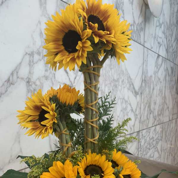 Sunflower arrangement with two tiers of blooms and greenery