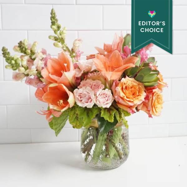 Orange and pink floral arrangement in a glass vase