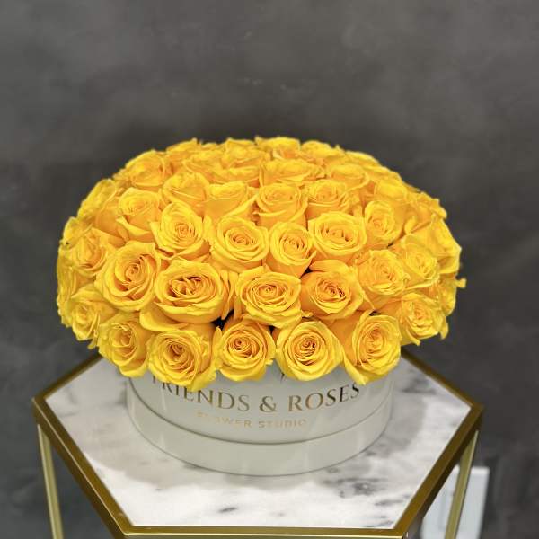 Round bouquet of yellow roses in a white hat box