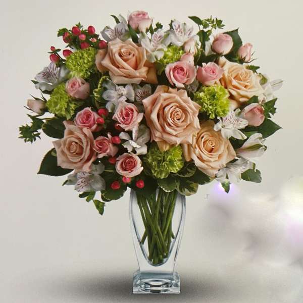 Bouquet of peach and pink roses in a clear glass vase