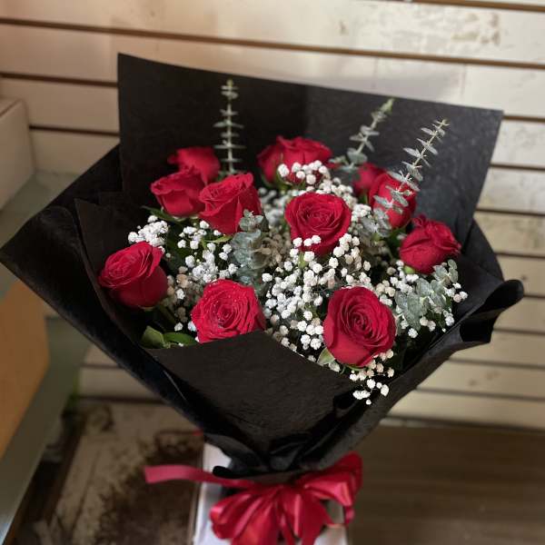 Bouquet of red roses with baby's breath in black wrap and a red ribbon