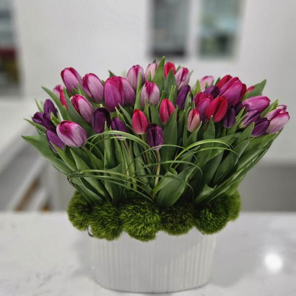 Bouquet of pink and purple tulips in a white vase