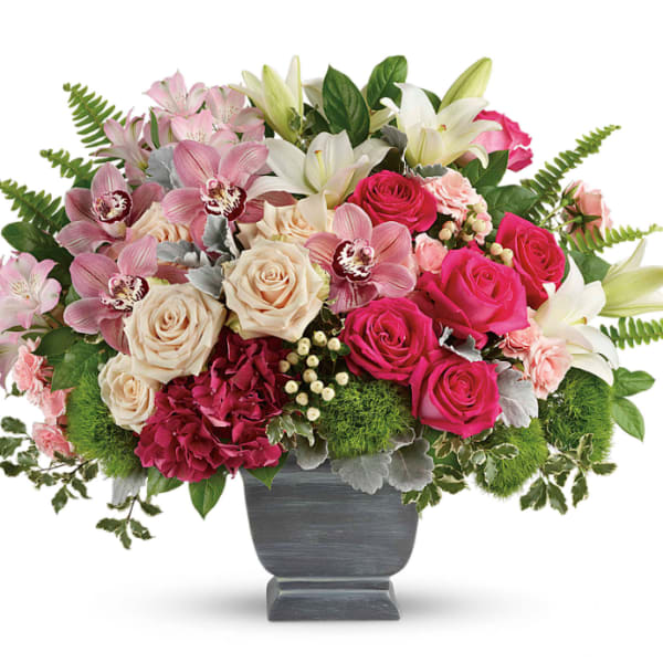 Mixed bouquet of roses, lilies, and orchids in a gray vase
