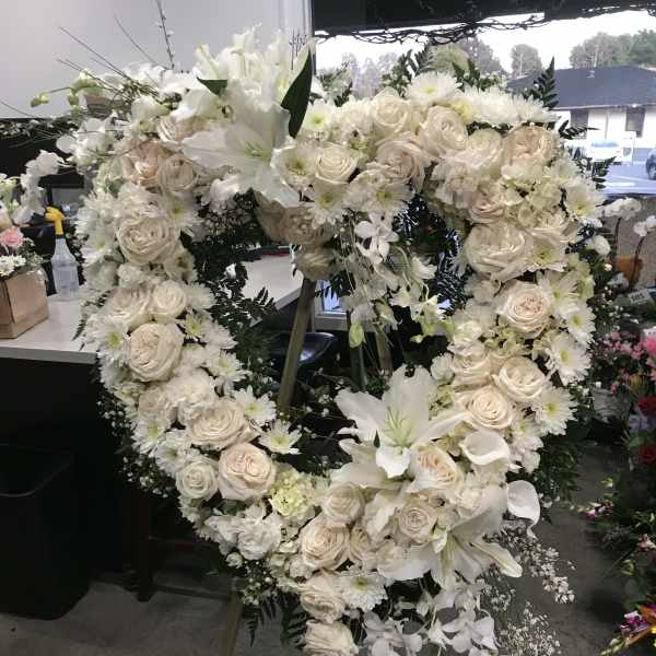 Large white floral heart wreath on an easel