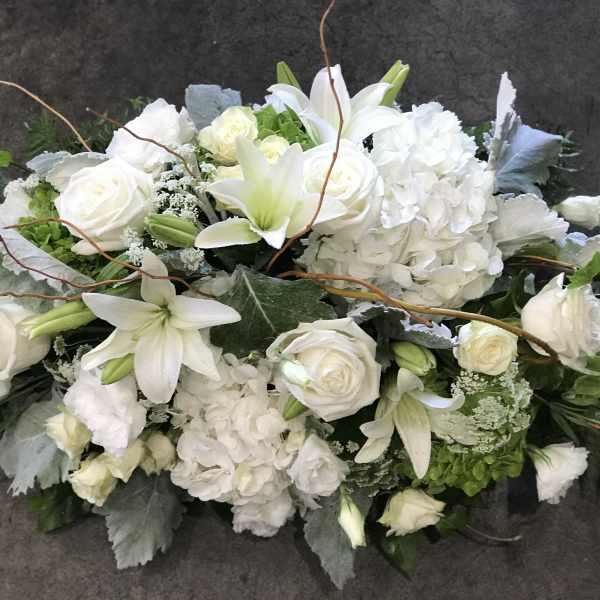 White floral arrangement with roses, lilies, and hydrangeas