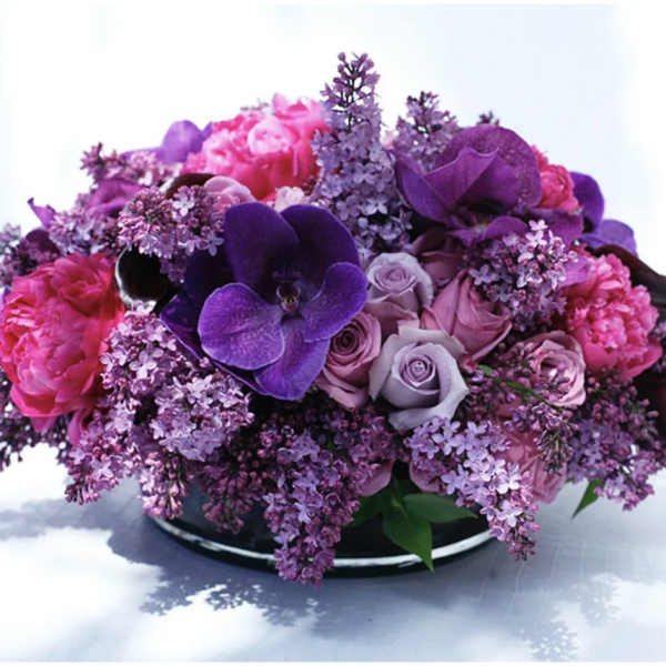 Purple and pink floral arrangement in a low black container