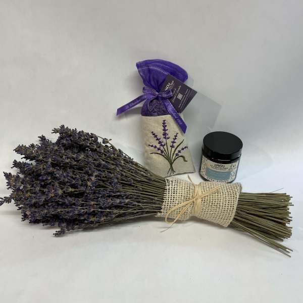 Bundle of dried lavender with a small candle jar and sachet