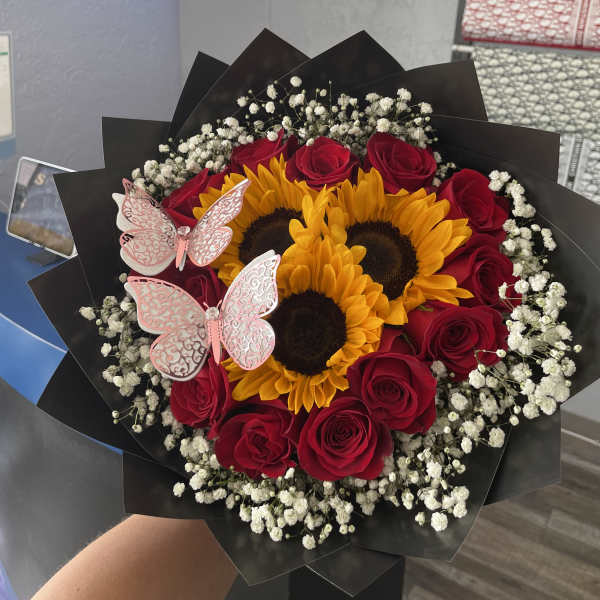 Bouquet of red roses and sunflowers with pink butterfly decorations