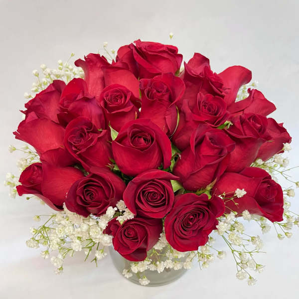 Bouquet of red roses with white baby's breath in a clear vase