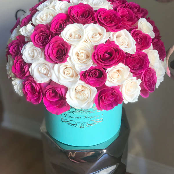 Bouquet of pink and white roses in a turquoise hat box