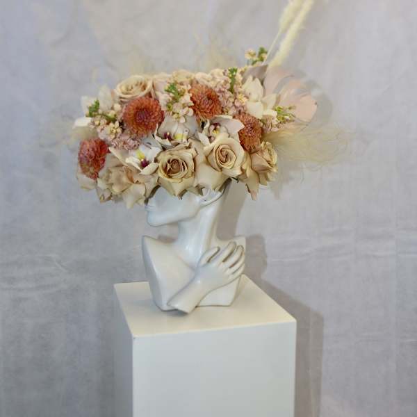 Floral crown on a white bust with cream and peach blooms