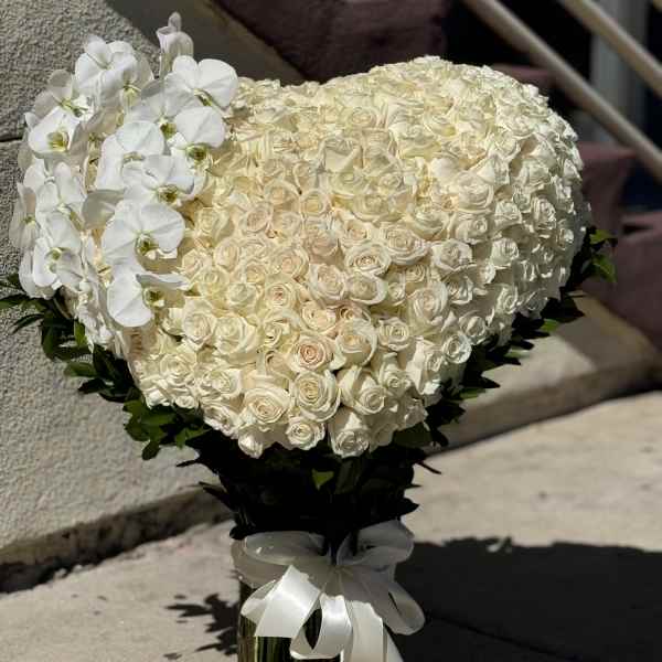 Heart-shaped bouquet of white roses with white orchids and a ribbon wrap