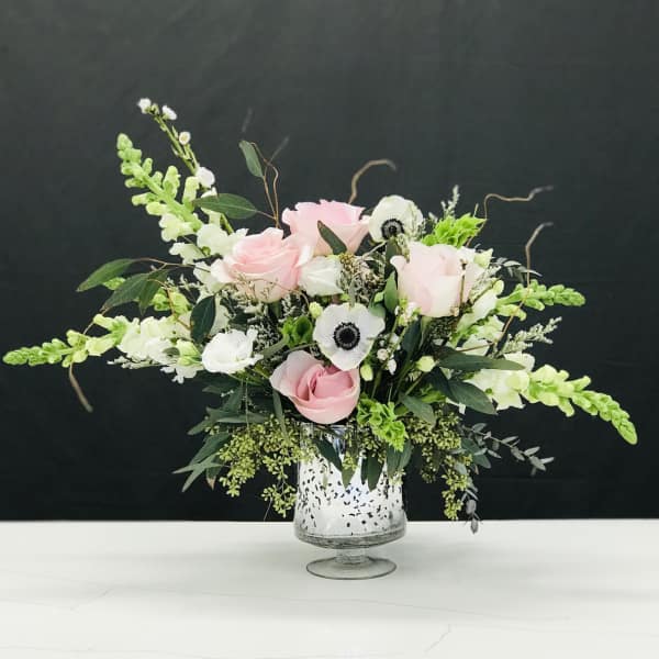 Pink roses and white anemones in a glass vase