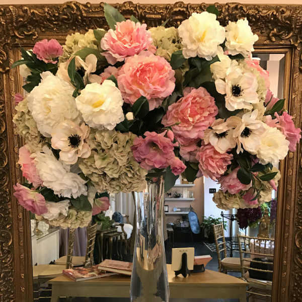 Large pink and white floral arrangement in a tall glass vase